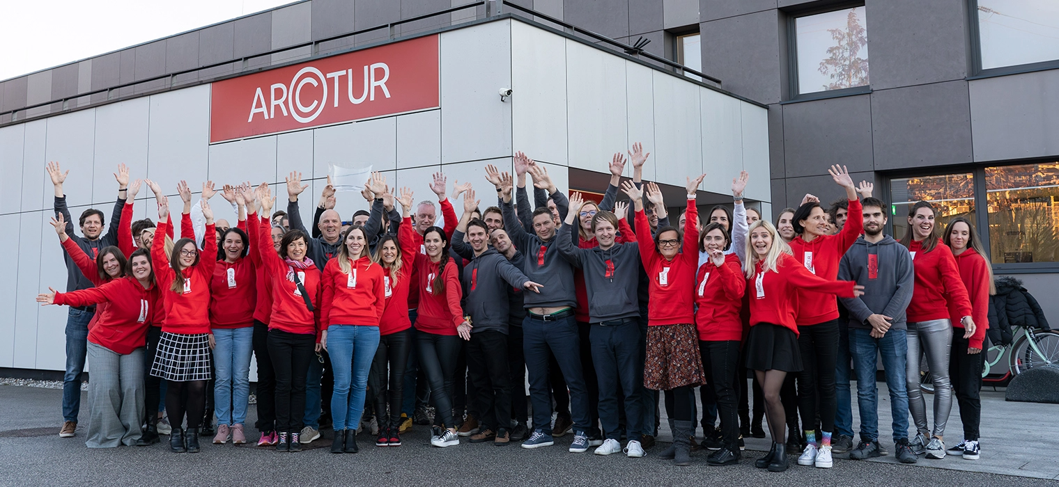 Arctur employees waving in front of the Arctur company entrance