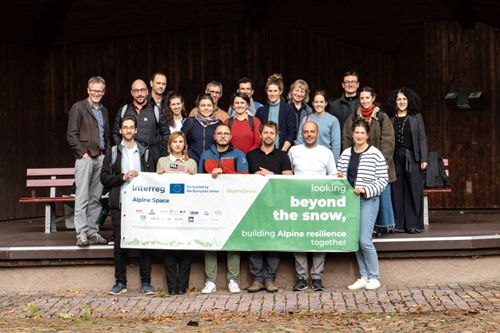 Group photo of the consortium for the Beyond Snow project, 20 people in three rows. First row holding a Beyond Snow baner, with project logo and financing logos.