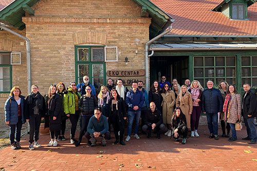 people standing in front of a house. a group of around 30 people